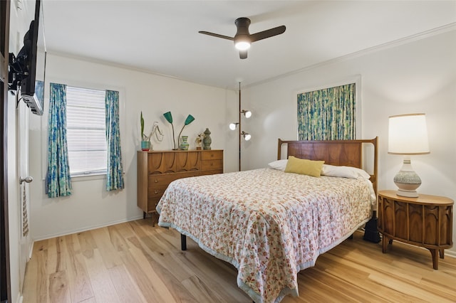 bedroom with light wood-style floors, baseboards, a ceiling fan, and ornamental molding