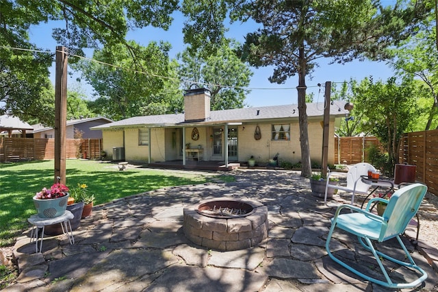 rear view of house with a yard, an outdoor fire pit, fence private yard, and a patio
