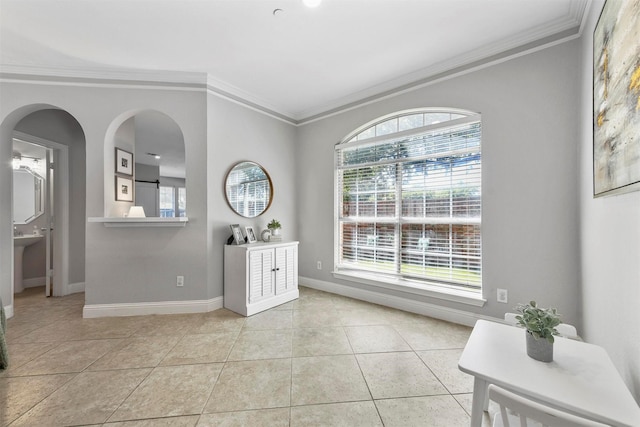 interior space with crown molding, light tile patterned floors, and baseboards