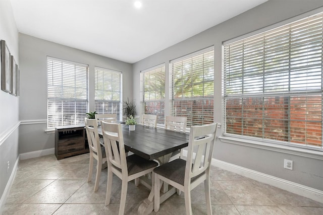 dining area featuring light tile patterned flooring and baseboards
