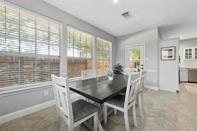 dining room featuring baseboards, light tile patterned floors, and visible vents