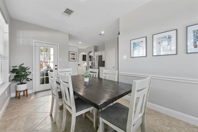 dining area featuring arched walkways, recessed lighting, light tile patterned floors, and visible vents