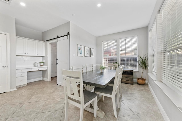 dining room featuring light tile patterned floors, recessed lighting, baseboards, and a barn door