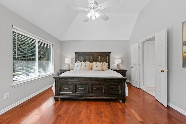 bedroom with multiple windows, dark wood finished floors, baseboards, and lofted ceiling