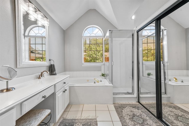 full bathroom featuring vanity, lofted ceiling, a garden tub, and tile patterned flooring