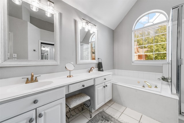 full bath with a sink, tile patterned floors, a garden tub, double vanity, and vaulted ceiling