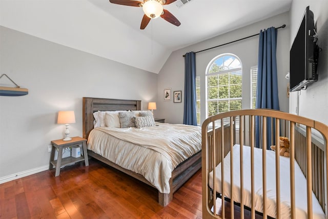 bedroom with a ceiling fan, visible vents, baseboards, vaulted ceiling, and hardwood / wood-style flooring