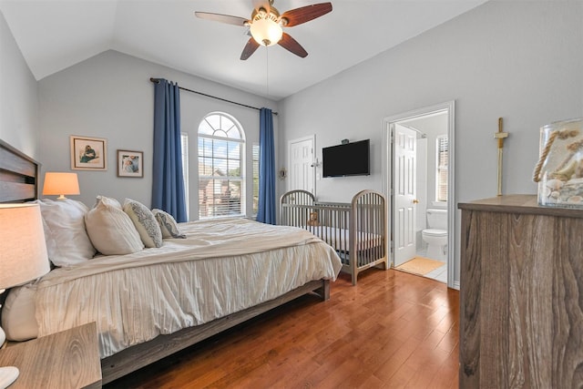 bedroom with connected bathroom, vaulted ceiling, wood finished floors, and ceiling fan