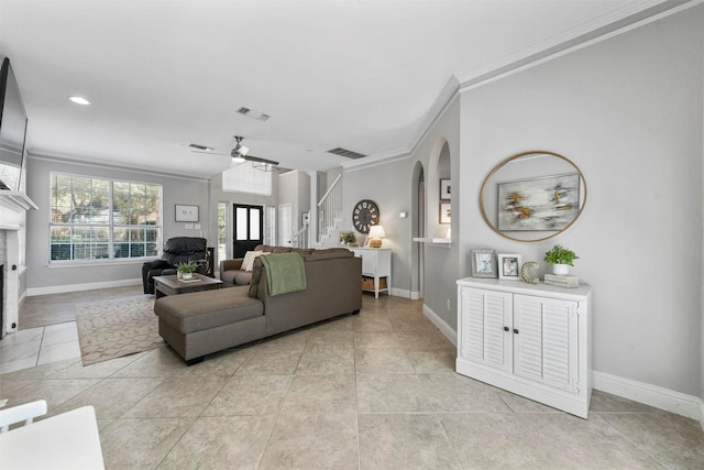 living room with stairway, arched walkways, a fireplace with flush hearth, and visible vents