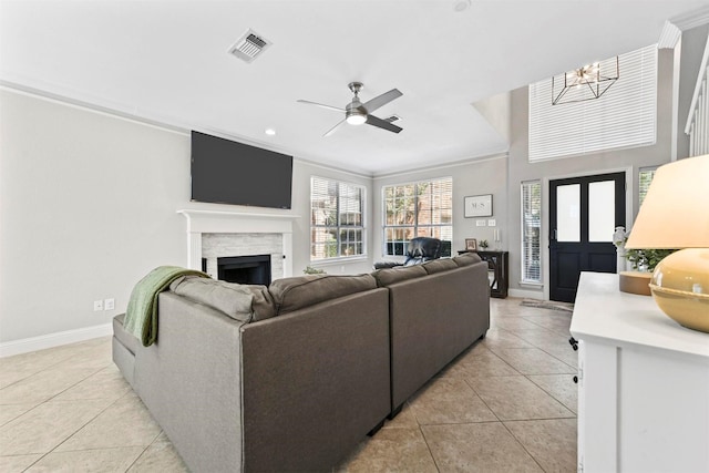 living area with light tile patterned floors, crown molding, a fireplace, and visible vents