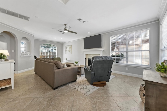 living area featuring baseboards, visible vents, and crown molding