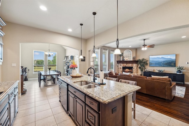 kitchen featuring recessed lighting, a fireplace, light tile patterned flooring, and a sink