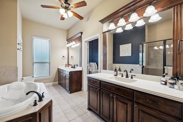 bathroom with a stall shower, ceiling fan, a sink, tile patterned floors, and two vanities
