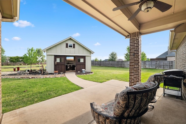 view of patio / terrace featuring fence, a ceiling fan, and an outbuilding