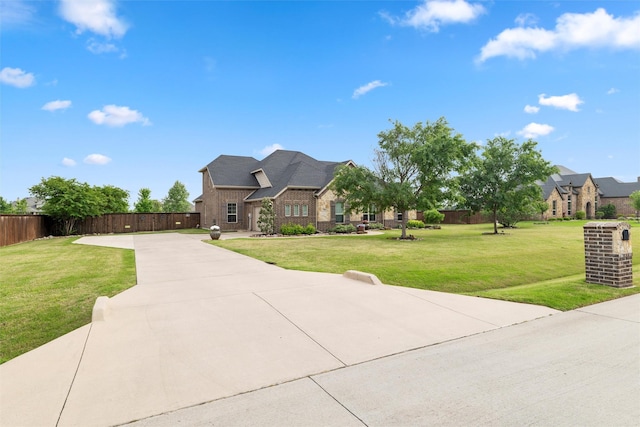 french country home with fence, a front lawn, brick siding, and driveway