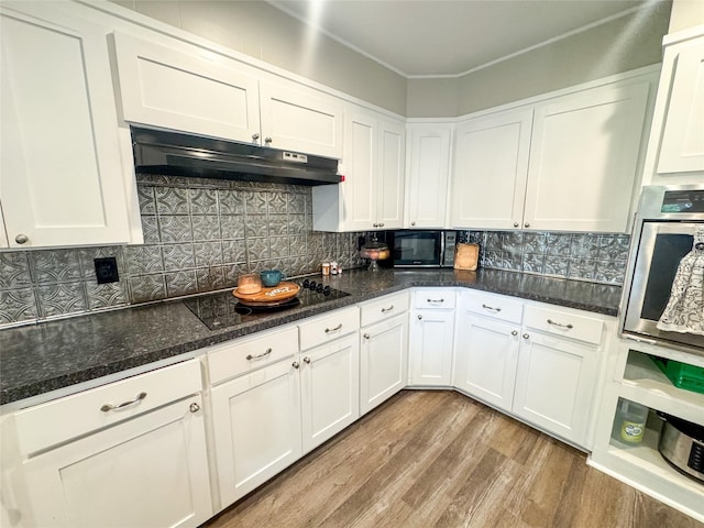 406 Mockingbird Ln, Chico, TX 76431 - kitchen with under cabinet range hood, white cabinetry, wood finished floors, and black appliances