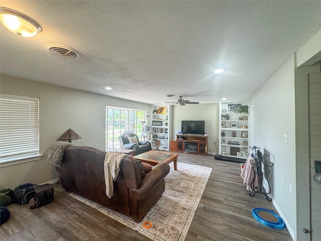 406 Mockingbird Ln, Chico, TX 76431 - living room with a ceiling fan, a textured ceiling, visible vents, built in features, and wood finished floors