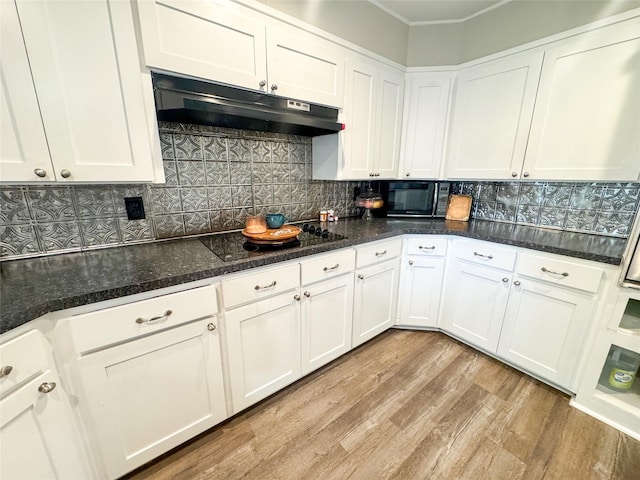 406 Mockingbird Ln, Chico, TX 76431 - kitchen with light wood-style flooring, white cabinetry, black appliances, backsplash, and under cabinet range hood