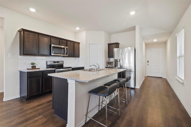 1628 Seadrift Dr, Forney, TX 75126 - kitchen featuring stainless steel appliances, dark wood-type flooring, decorative backsplash, a breakfast bar, and dark brown cabinetry