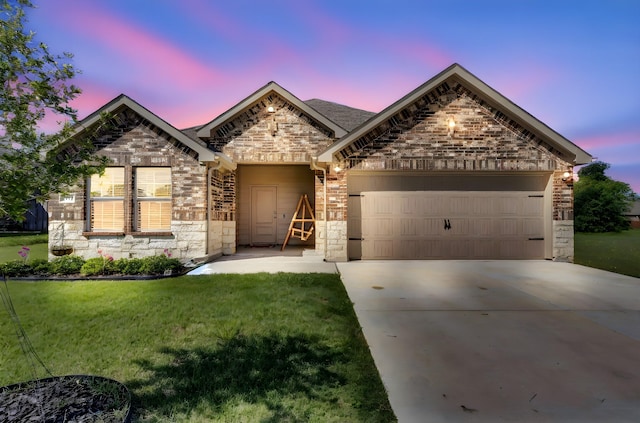 view of front of property with concrete driveway, stone siding, an attached garage, and a front yard