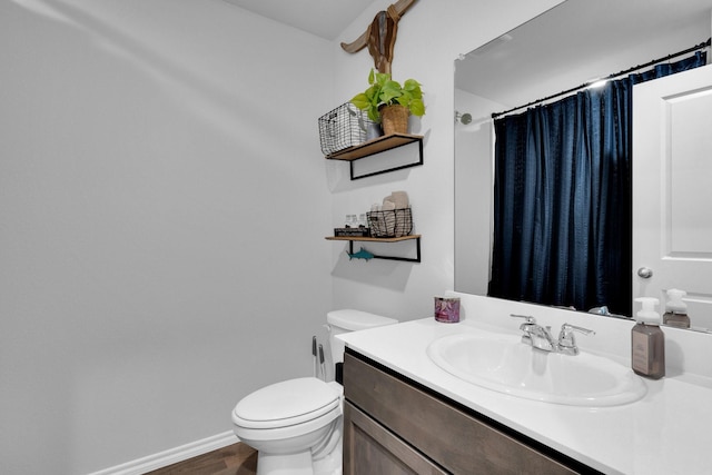 bathroom featuring curtained shower, vanity, toilet, and wood finished floors