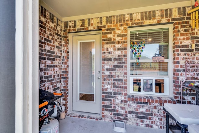 property entrance featuring brick siding