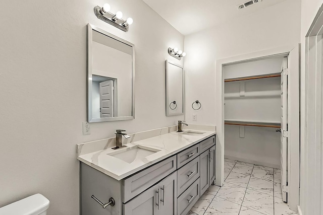 503 W Martin Luther King St, Denison, TX 75020 - full bathroom featuring toilet, marble finish floor, visible vents, and a sink