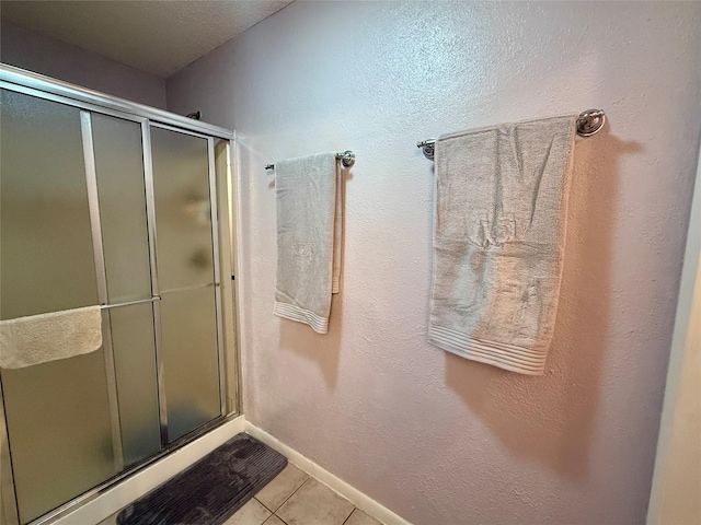 full bathroom featuring baseboards, a shower stall, and tile patterned floors