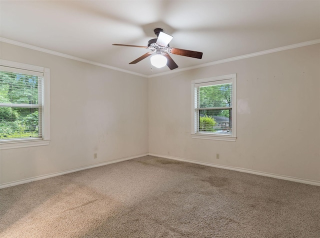 carpeted empty room with ceiling fan, baseboards, and ornamental molding