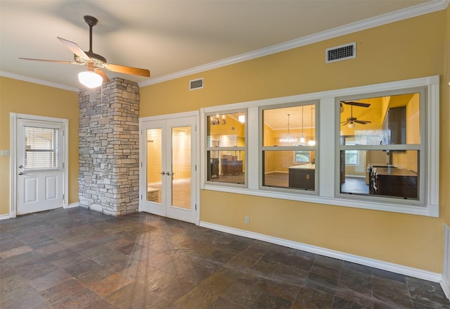interior space with crown molding, visible vents, a ceiling fan, and stone finish floor