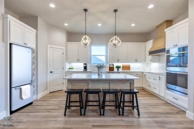 3342 Torrey Pne, Abilene, TX 79606 - kitchen with stainless steel appliances, light stone counters, a breakfast bar area, white cabinets, and a kitchen island
