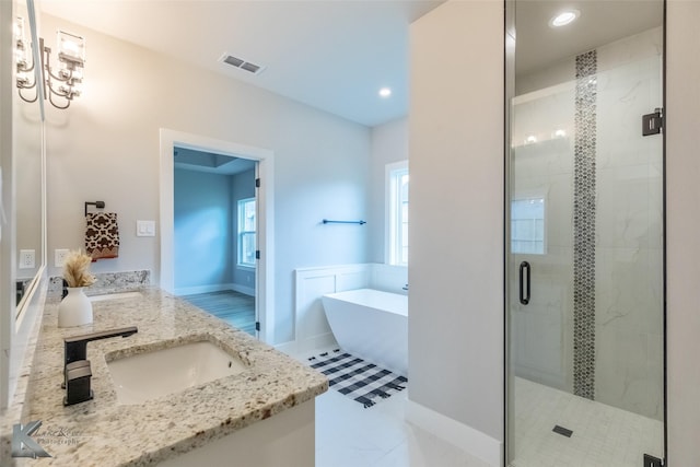 3342 Torrey Pne, Abilene, TX 79606 - bathroom featuring double vanity, a sink, visible vents, a shower stall, and a freestanding tub