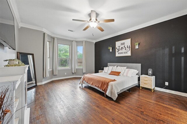 bedroom featuring ornamental molding, baseboards, visible vents, and wood finished floors