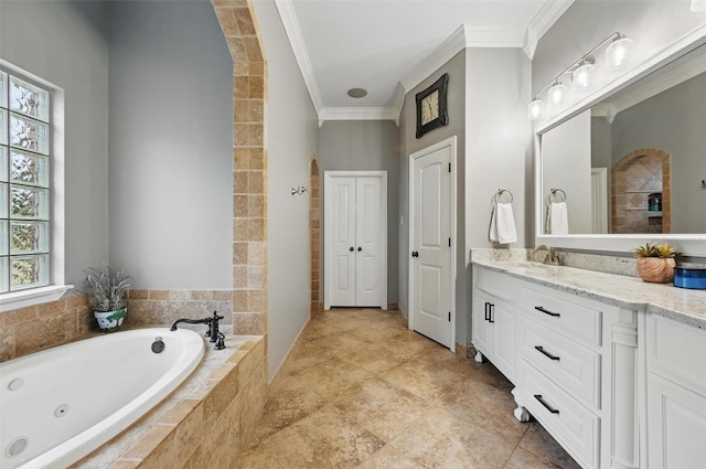 bathroom with a tub with jets, vanity, and crown molding