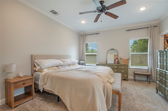 carpeted bedroom featuring multiple windows, visible vents, baseboards, and crown molding