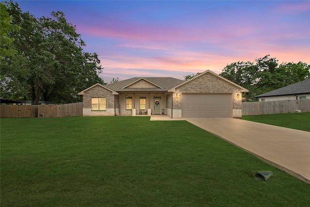 ranch-style house with a porch, an attached garage, brick siding, driveway, and a yard