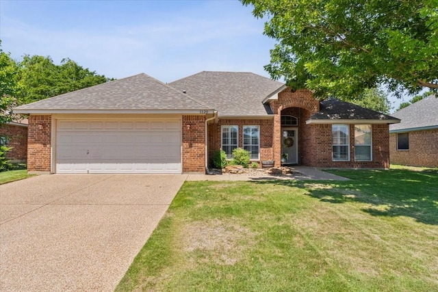 ranch-style house with an attached garage, concrete driveway, a front lawn, brick siding, and roof with shingles