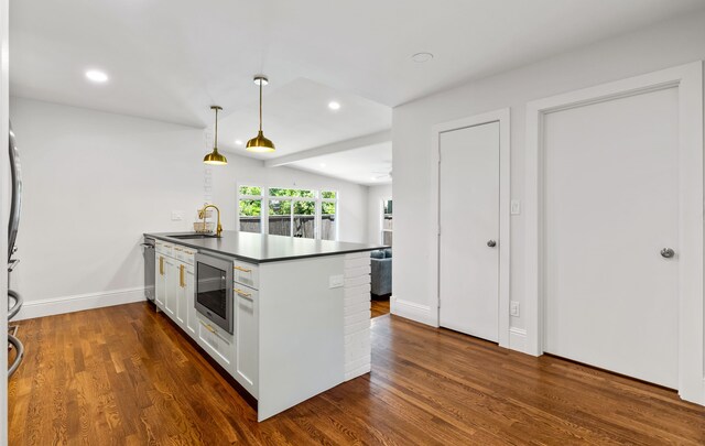 8831 Lanarkshire Dr, Dallas, TX 75238 - kitchen with stainless steel microwave, a peninsula, a sink, dark countertops, and dark wood-type flooring