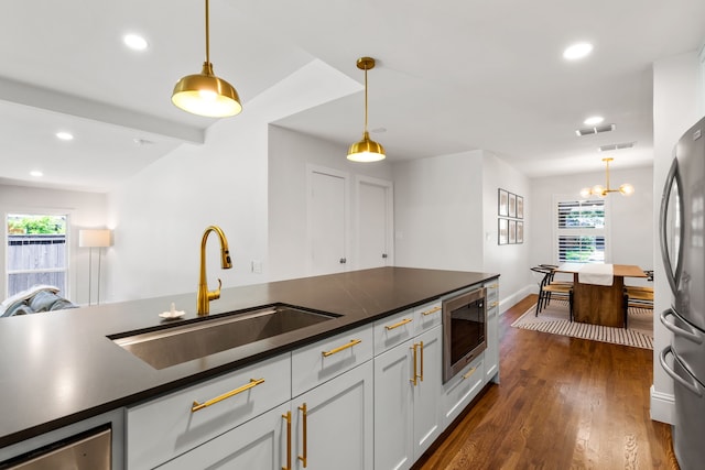 8831 Lanarkshire Dr, Dallas, TX 75238 - kitchen featuring appliances with stainless steel finishes, a sink, healthy amount of natural light, dark countertops, and recessed lighting