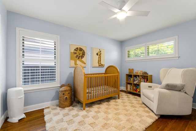 8831 Lanarkshire Dr, Dallas, TX 75238 - bedroom featuring wood finished floors, baseboards, and a crib