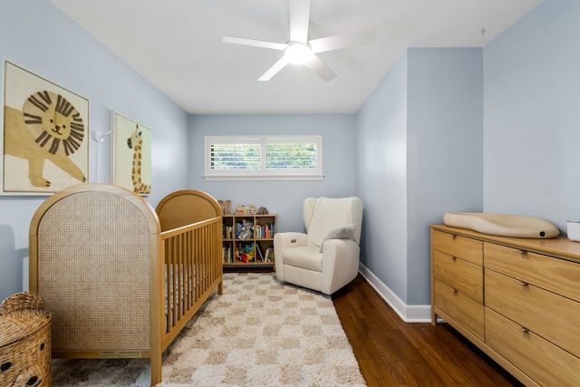 8831 Lanarkshire Dr, Dallas, TX 75238 - bedroom with wood finished floors, a crib, baseboards, and a ceiling fan