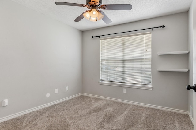 carpeted spare room featuring baseboards, ceiling fan, and a textured ceiling