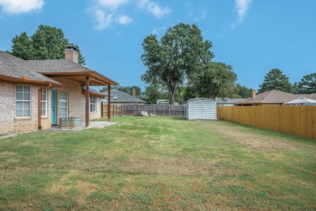 view of yard with a fenced backyard, an outdoor structure, and a shed