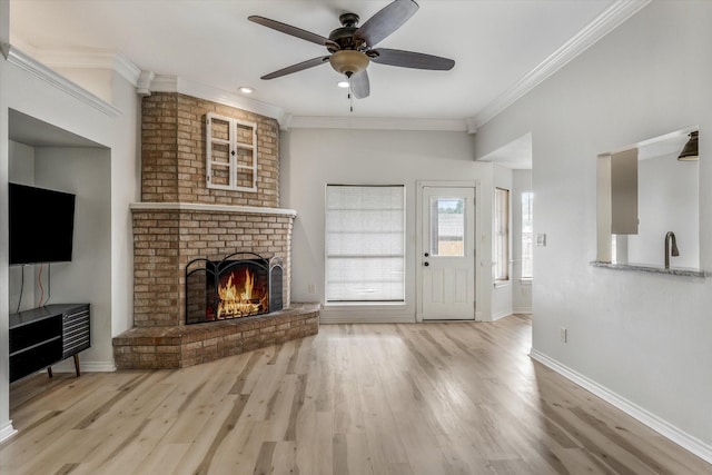 unfurnished living room featuring wood finished floors, a ceiling fan, a brick fireplace, baseboards, and ornamental molding
