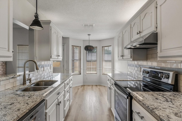 kitchen featuring a sink, stainless steel appliances, light stone countertops, under cabinet range hood, and light wood-style floors