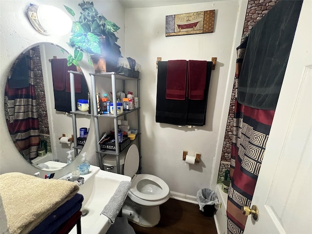 full bath with toilet, wood finished floors, curtained shower, baseboards, and vanity