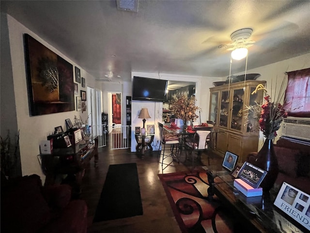 living area with cooling unit, a ceiling fan, and visible vents