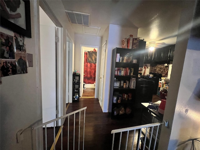 hallway featuring an upstairs landing, attic access, visible vents, and dark wood-style floors