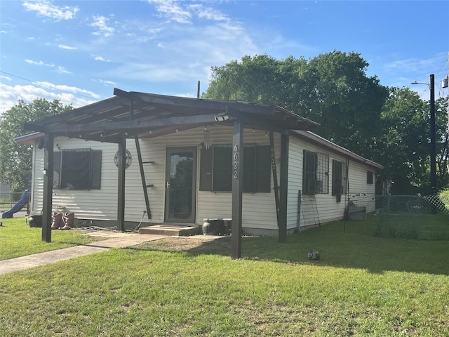 view of front facade with a front lawn and fence