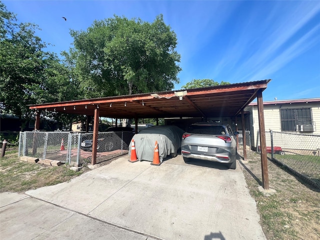 view of parking / parking lot with driveway and fence